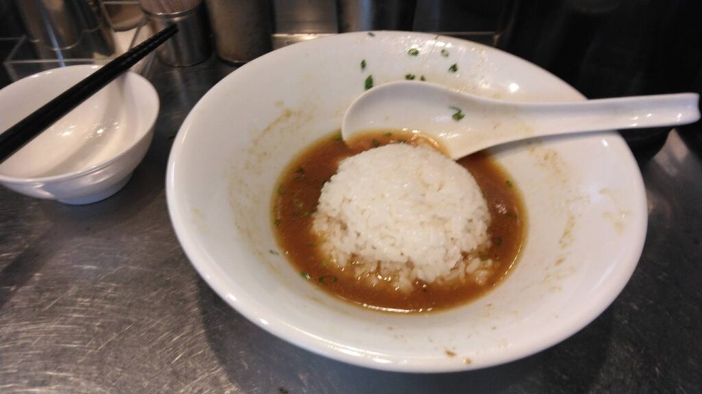 台東区東上野、さんじさん：限定４ゴロゴロ貝まみれカレー蕎麦のスープへ小ライスをドボン